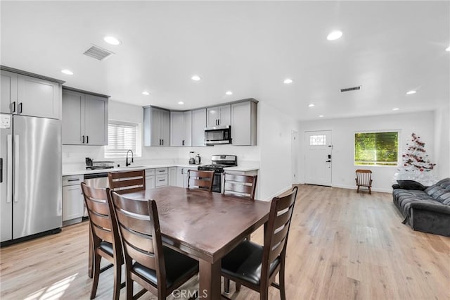 dining room featuring sink and light hardwood / wood-style floors