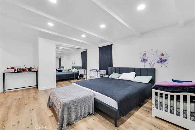 bedroom featuring beamed ceiling and light hardwood / wood-style flooring