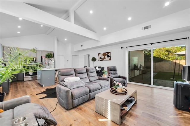 living room with beam ceiling, high vaulted ceiling, and light wood-type flooring