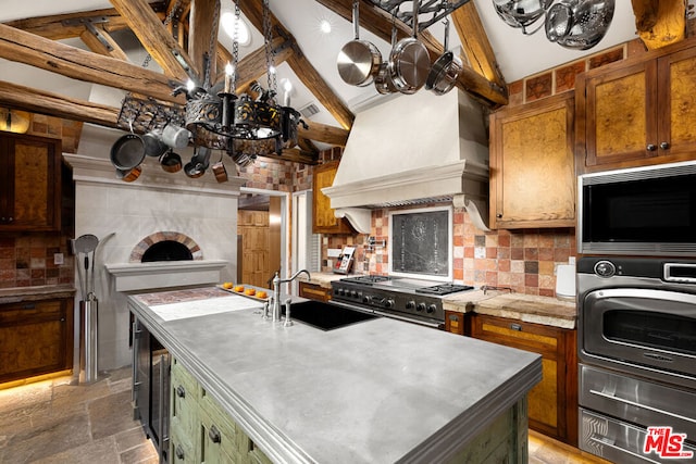 kitchen with premium range hood, appliances with stainless steel finishes, high vaulted ceiling, tasteful backsplash, and sink