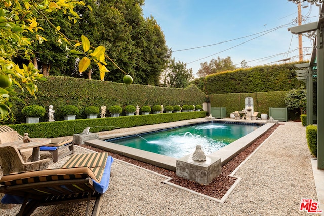 view of pool featuring pool water feature and a patio area