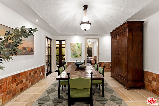 dining space featuring a tray ceiling and a textured ceiling