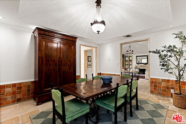 dining room featuring a textured ceiling and a notable chandelier