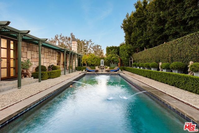 view of pool featuring pool water feature and a patio