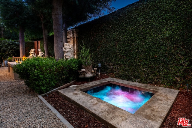 view of swimming pool featuring a hot tub