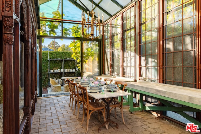 sunroom with lofted ceiling and a notable chandelier