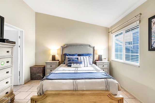 bedroom with light tile patterned floors and vaulted ceiling