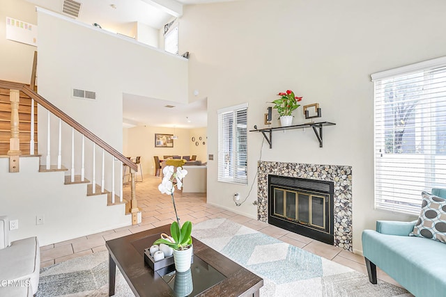 tiled living room featuring a tile fireplace, beam ceiling, and high vaulted ceiling