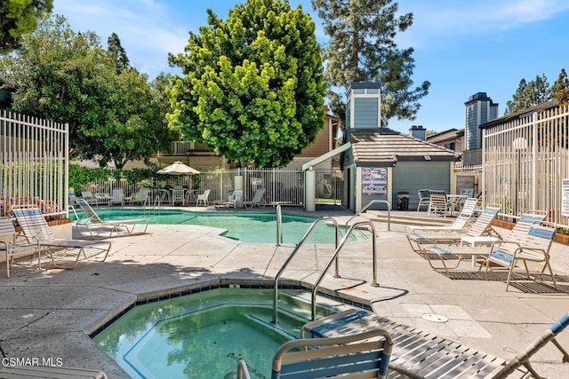 view of swimming pool featuring a community hot tub and a patio