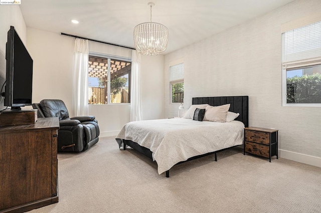 carpeted bedroom featuring an inviting chandelier