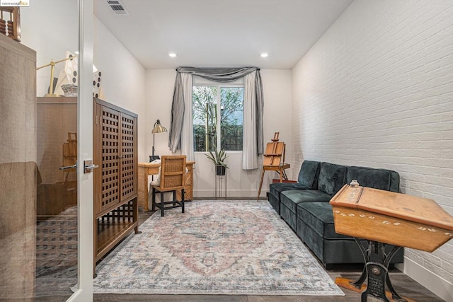 living area featuring brick wall