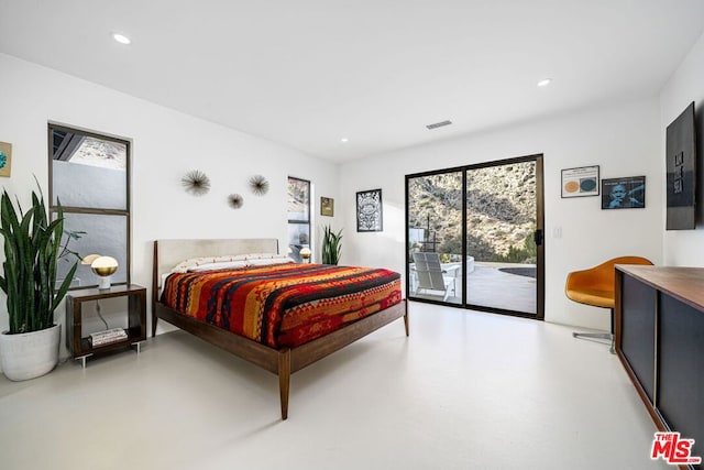 bedroom with access to outside and concrete floors