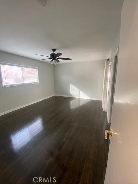 empty room featuring dark hardwood / wood-style floors and ceiling fan