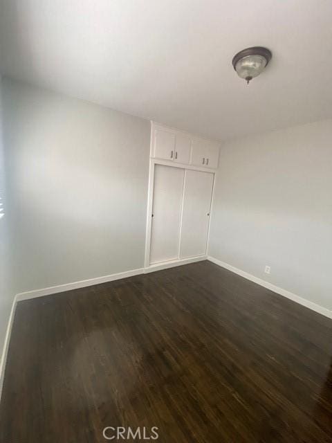 empty room with dark hardwood / wood-style flooring