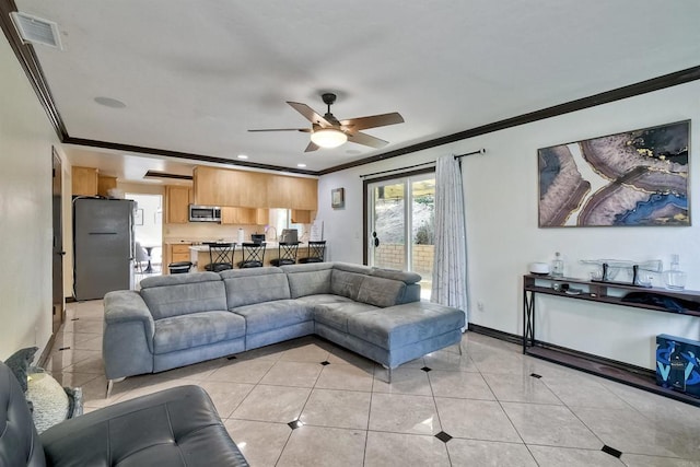 tiled living room with ceiling fan and ornamental molding