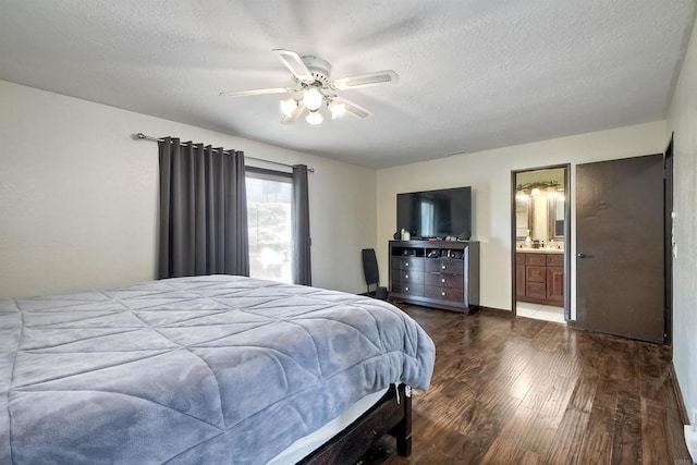 bedroom with connected bathroom, ceiling fan, dark hardwood / wood-style flooring, and a textured ceiling