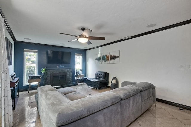 tiled living room with a stone fireplace, ceiling fan, and ornamental molding