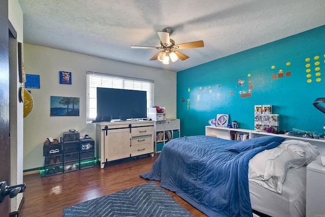 bedroom featuring a textured ceiling, ceiling fan, and dark wood-type flooring