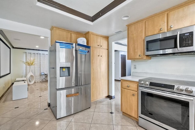 kitchen with appliances with stainless steel finishes, light brown cabinets, light tile patterned floors, and crown molding