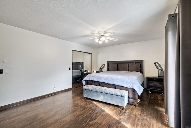 bedroom with ceiling fan, dark hardwood / wood-style flooring, and a textured ceiling