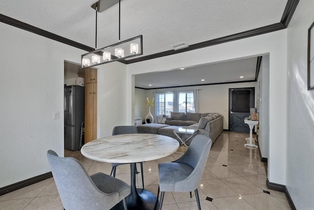 tiled dining area featuring ornamental molding and a textured ceiling