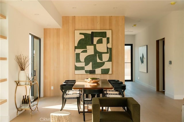 dining room featuring plenty of natural light and wooden walls