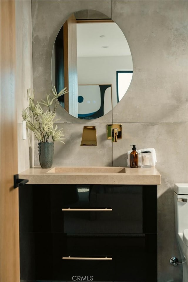 bathroom with vanity, toilet, and backsplash