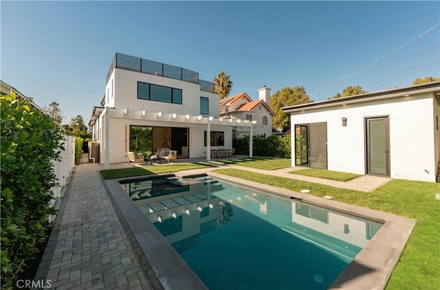 rear view of property with a yard, a patio, and an outdoor hangout area