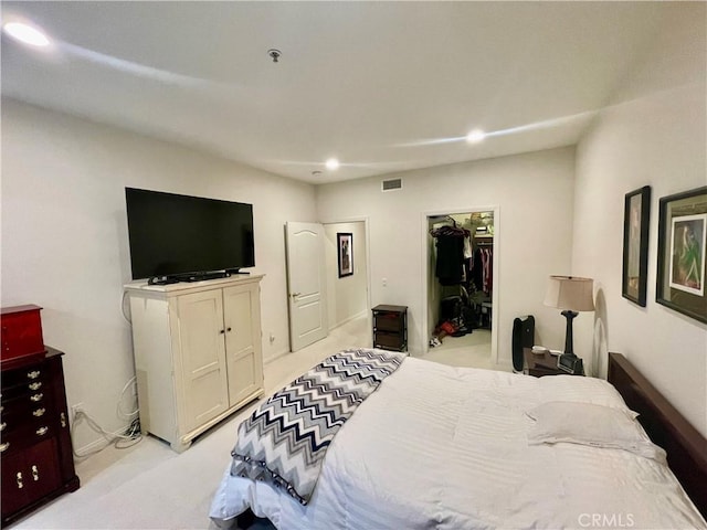 bedroom featuring light carpet, a spacious closet, and a closet