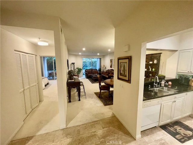 hall with sink and light carpet