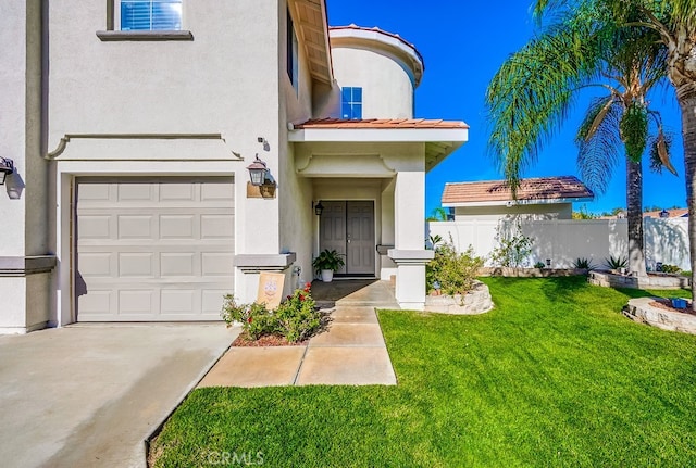 view of exterior entry with a garage and a lawn