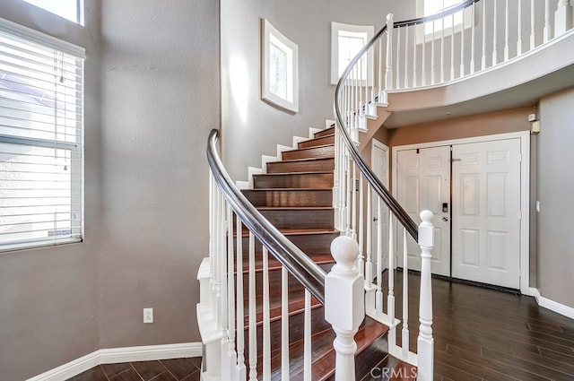 stairs featuring a healthy amount of sunlight and a towering ceiling