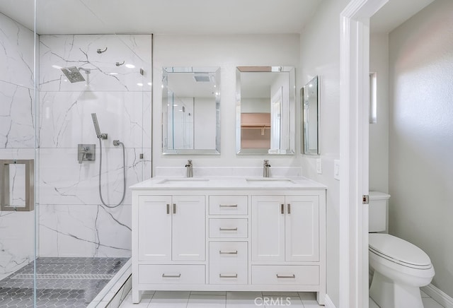 bathroom featuring toilet, a shower with door, vanity, and tile patterned flooring