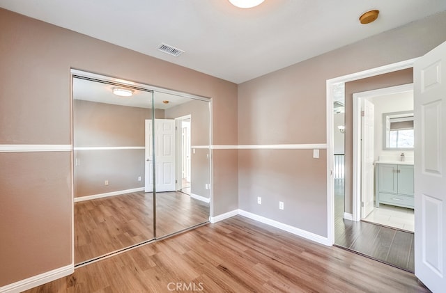 unfurnished bedroom featuring hardwood / wood-style flooring and a closet