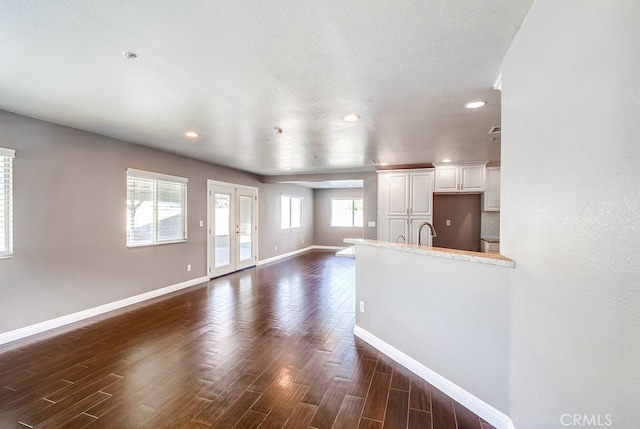 unfurnished living room with sink and dark hardwood / wood-style floors
