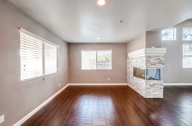 unfurnished living room with a fireplace and dark hardwood / wood-style floors