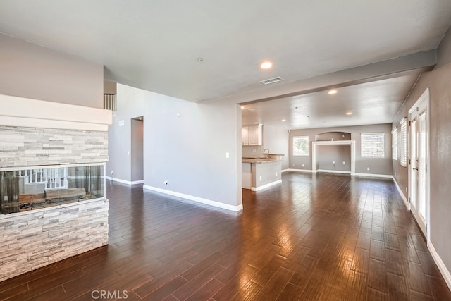 unfurnished living room with sink and dark hardwood / wood-style floors