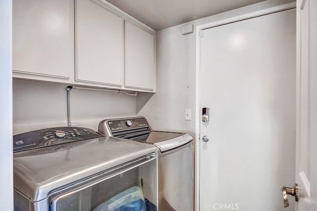 laundry area featuring separate washer and dryer and cabinets
