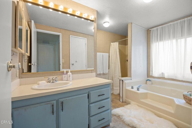 bathroom with vanity, a textured ceiling, and plus walk in shower