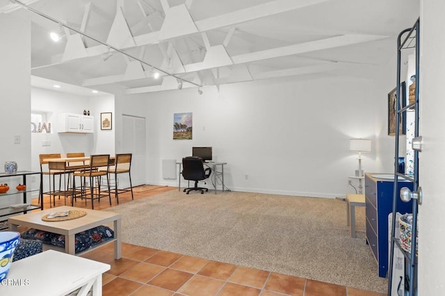 tiled office space with lofted ceiling with beams and track lighting