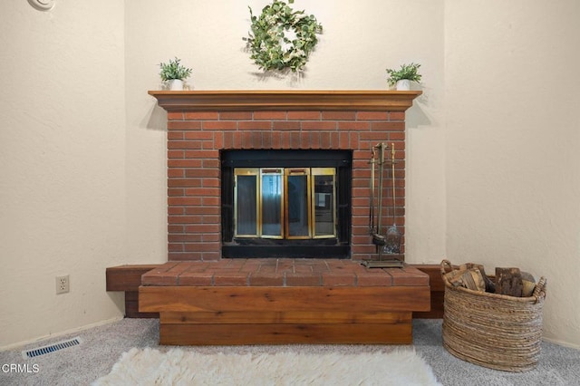 interior details with carpet floors and a brick fireplace