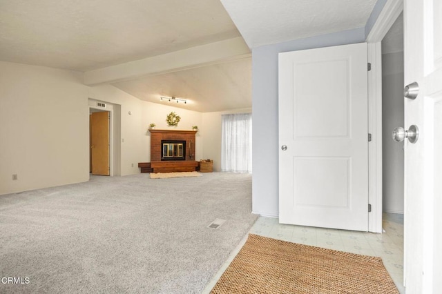 unfurnished living room featuring vaulted ceiling with beams, light colored carpet, and a brick fireplace