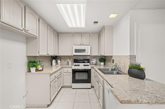 kitchen with kitchen peninsula, white appliances, white cabinetry, and sink