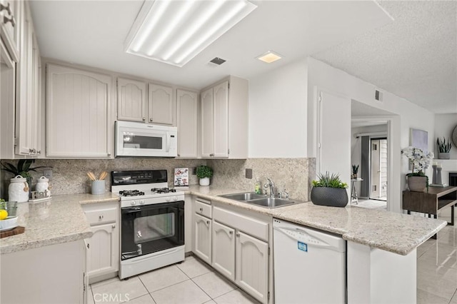 kitchen featuring kitchen peninsula, tasteful backsplash, white appliances, sink, and white cabinetry