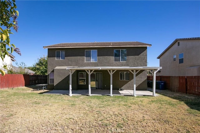 rear view of property with a yard and a patio