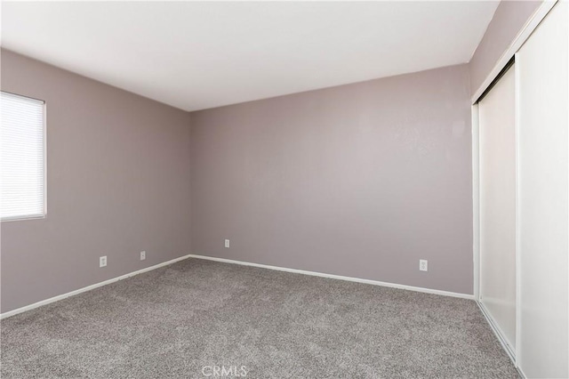 unfurnished bedroom featuring carpet flooring and a closet