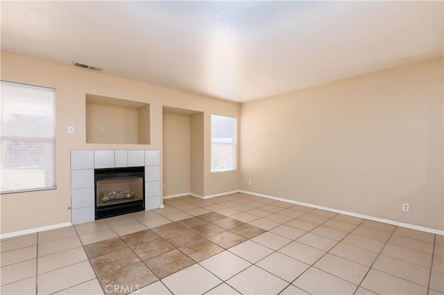 unfurnished living room with a healthy amount of sunlight, light tile patterned floors, and a fireplace