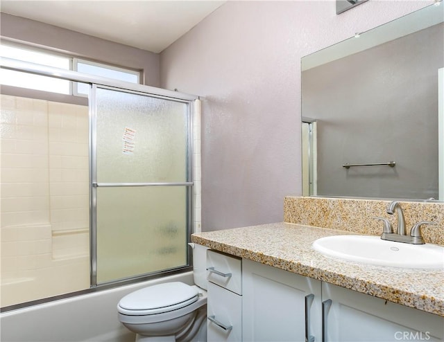 full bathroom featuring vanity, toilet, and enclosed tub / shower combo