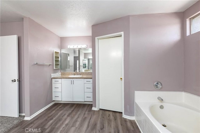 bathroom featuring a washtub, vanity, a textured ceiling, and hardwood / wood-style flooring