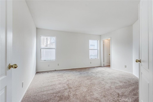 carpeted empty room with baseboards